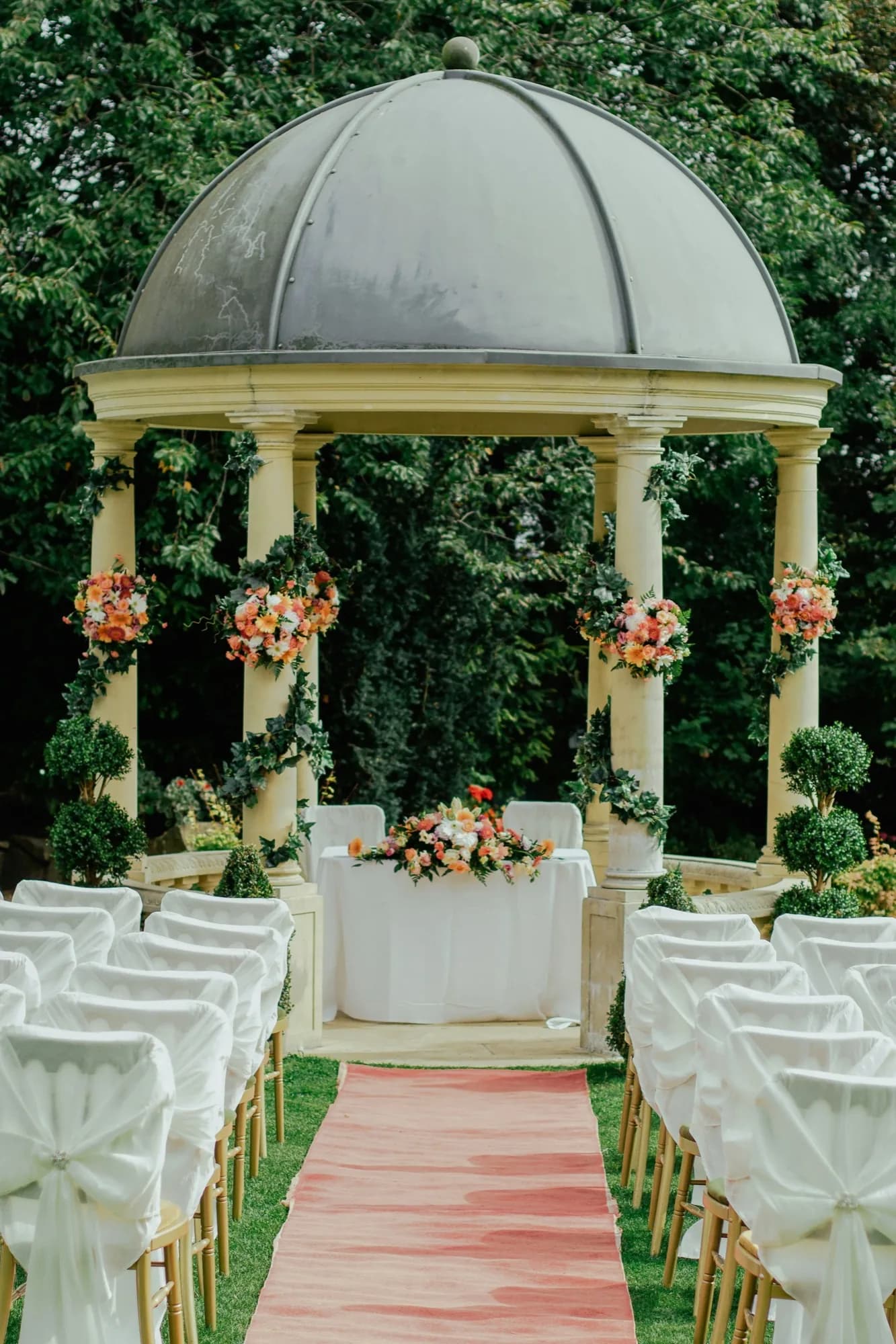 Pastel floral arch at an outdoor ceremony
