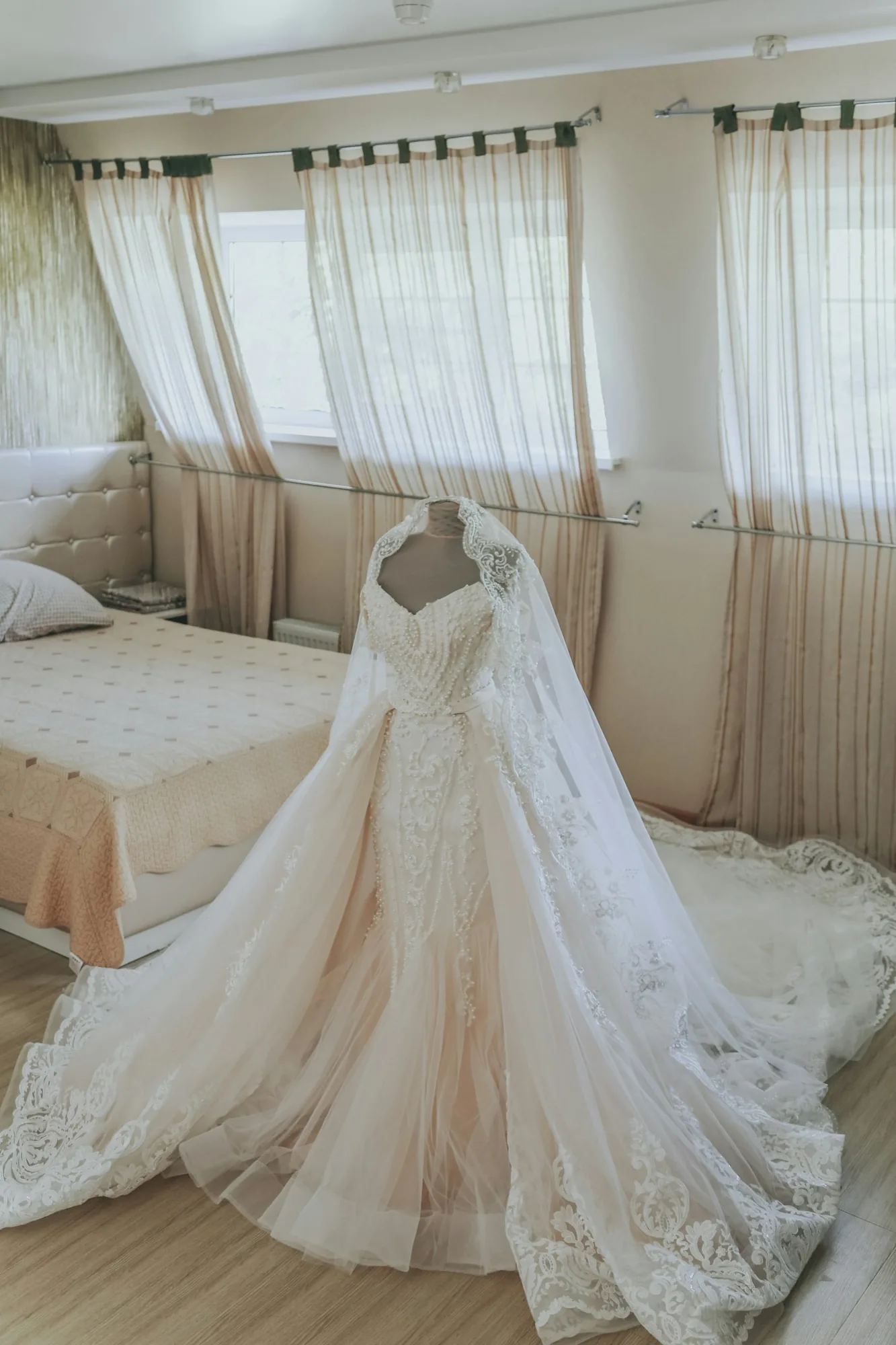 An embellished lace bridal gown with a long train, ready before the ceremony