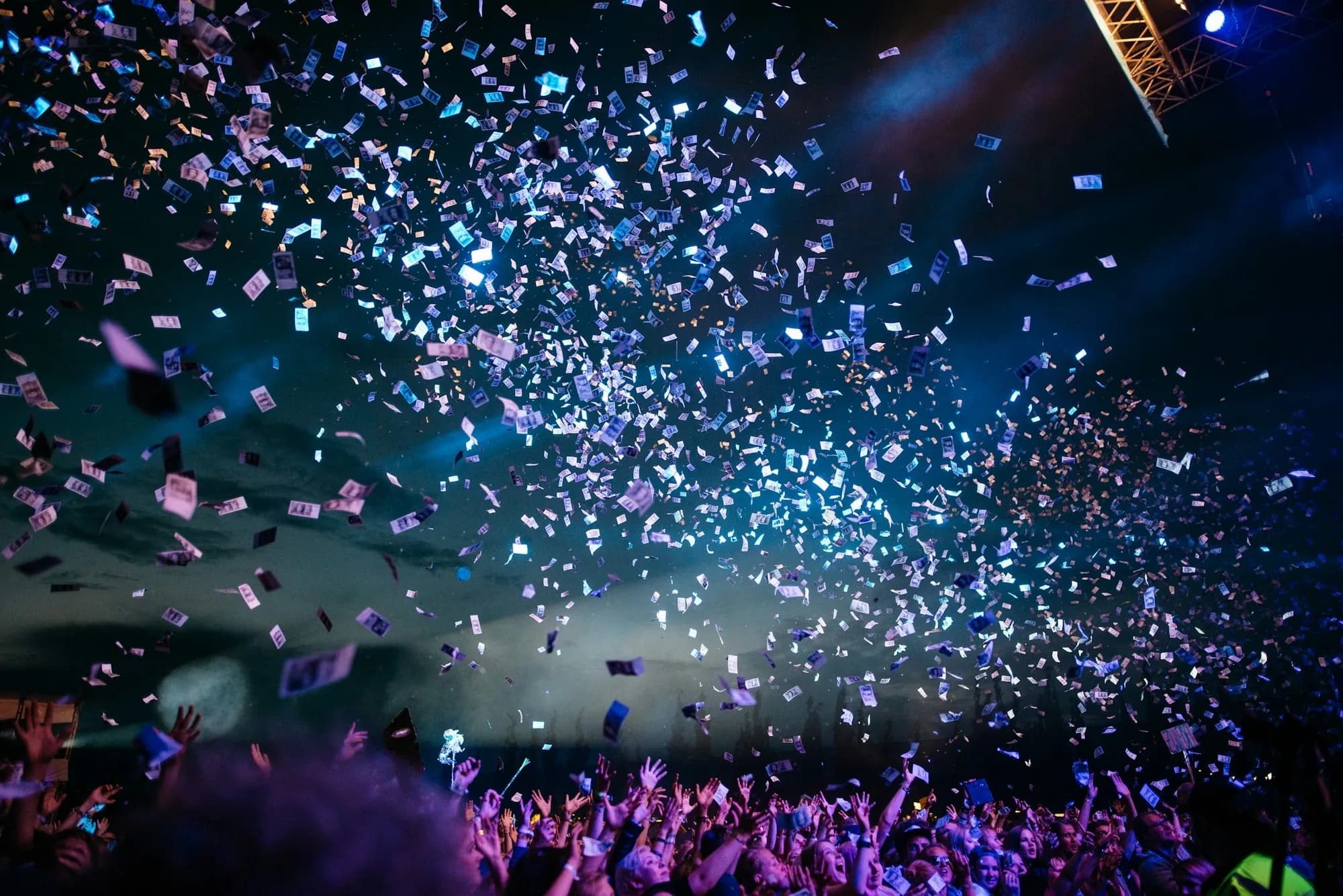 Confetti and stage lighting over a celebrating crowd