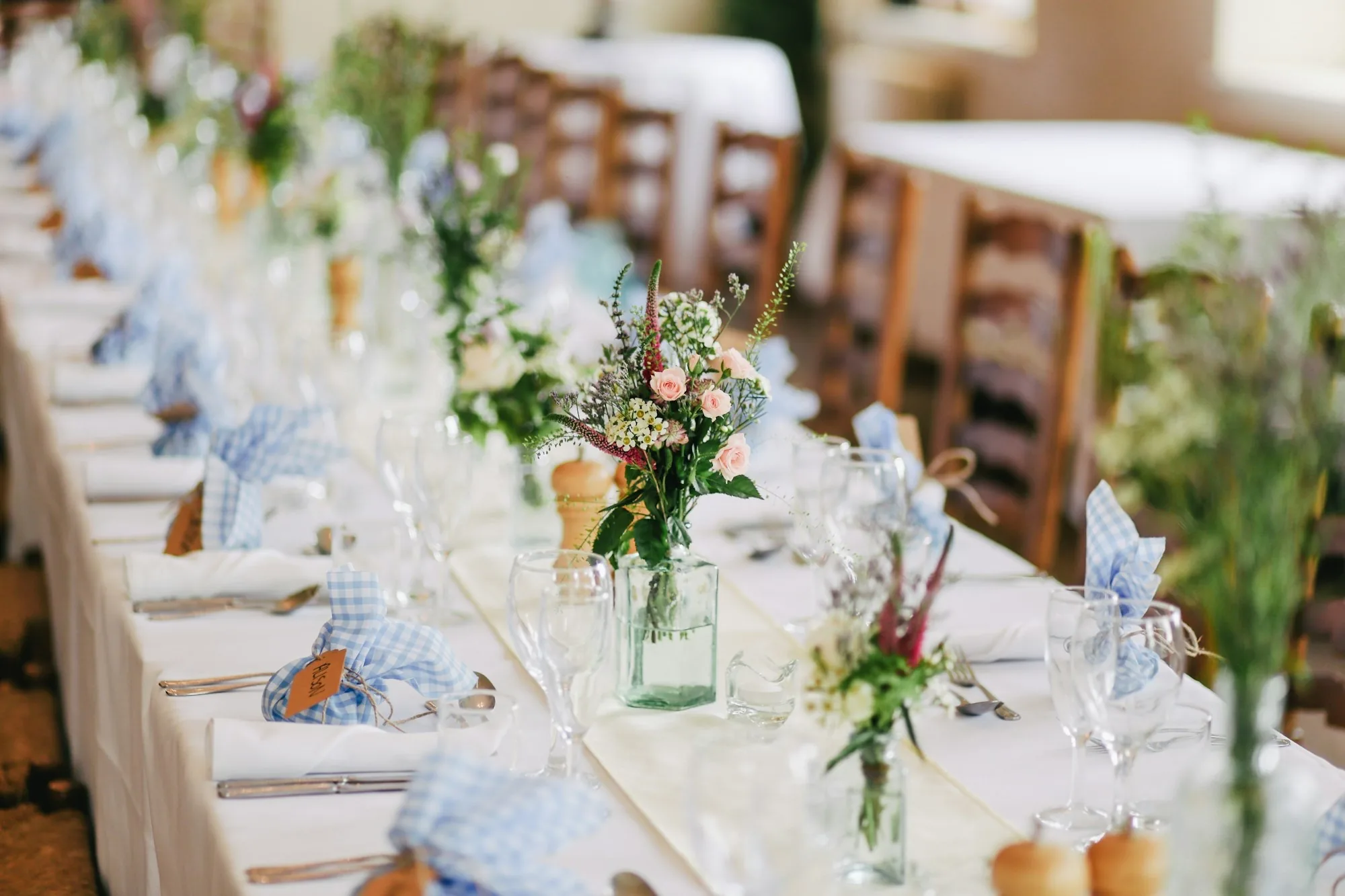 Long banquet table dressed with a greenery runner